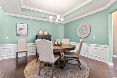 Dining space featuring a raised ceiling, dark wood