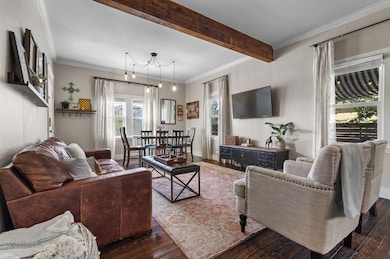 Living area with crown molding, hardwood / wood-style flooring, plenty of natural light, and beam ceiling