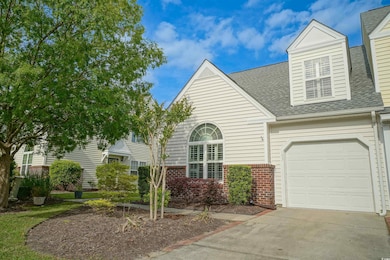 View of front of property featuring an attached garage, a shingled roof, brick siding, and concrete driveway