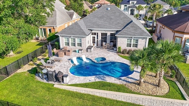 View of swimming pool featuring a patio, a fenced backyard, and a pool with connected hot tub