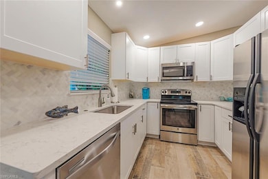 Kitchen featuring white cabinets, stainless steel 