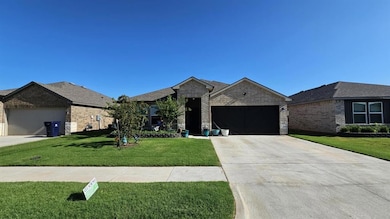 Ranch-style home with brick siding, an attached garage, a front yard, and concrete driveway