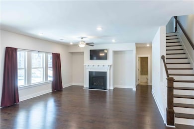 Unfurnished living room featuring ceiling fan and 