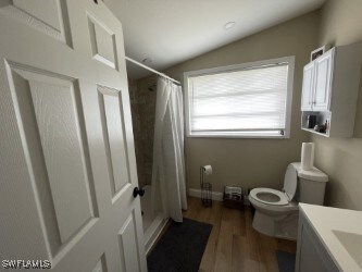 Full bath featuring toilet, a shower with shower c