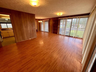 Living room looking towards dining area & kitchen, notice wrap around windows allowing lots of light.