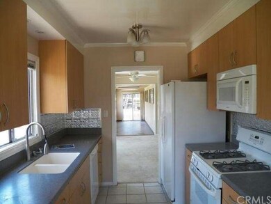 Kitchen leads to dining room with ceiling fan with