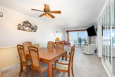 Dining area with a ceiling fan, light carpet, base