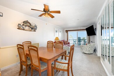 Dining area with a ceiling fan, light carpet, base