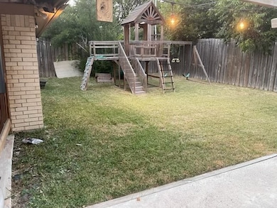 View of playground featuring a fenced backyard and a deck