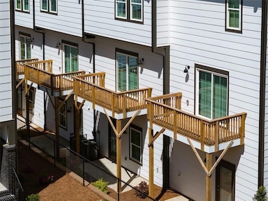 Rear view of house featuring a wooden deck and a patio area