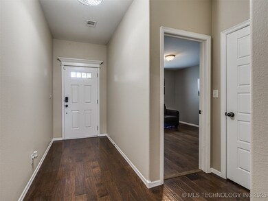 Doorway with dark wood-style flooring and baseboar
