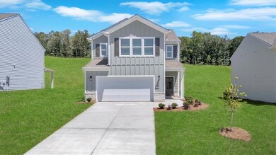 View of front of home featuring board and batten siding, an attached garage, concrete driveway, and a front yard