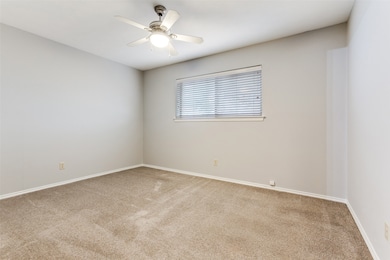 Spare room with light colored carpet and a ceiling fan