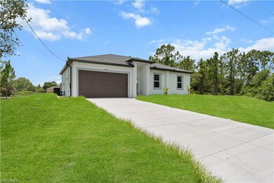 Prairie-style home with driveway, stucco siding, a garage, a front lawn, and roof with shingles
