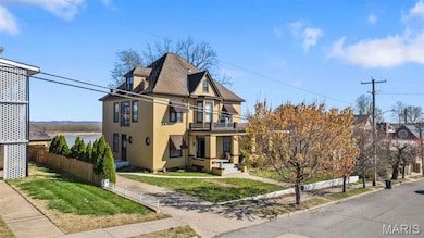 View of front of home with a shingled roof, stucco siding, and a fenced front yard