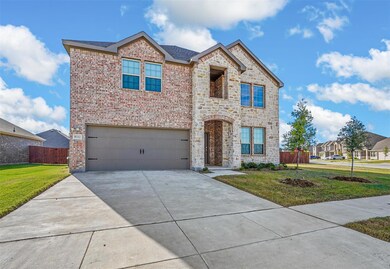 View of front of home with a front yard and a garage