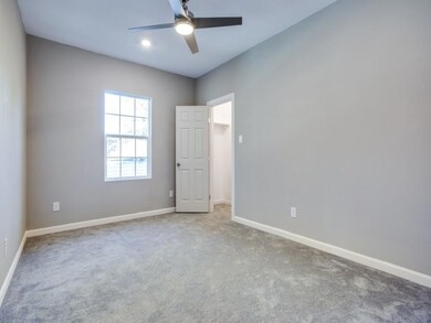 Carpeted empty room with ceiling fan and baseboard