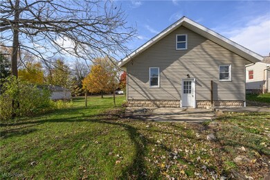 Back of property featuring a patio area and a lawn