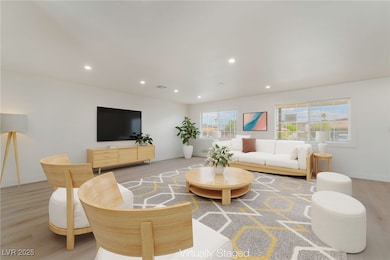 Living area with recessed lighting and light wood-style floors