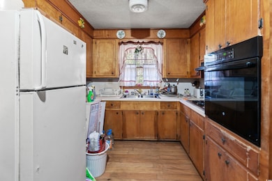 Kitchen with a textured ceiling, light countertops