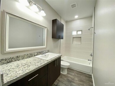 Bathroom featuring toilet, shower / bathtub combination, visible vents, and wood finished floors