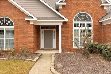 Entrance to property with roof with shingles and brick siding