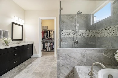 The Main-Level Primary Suite is a True Retreat, featuring a  Spa-Inspired Bathroom with Dual Vanities, a Tiled Shower, a Soaking Tub, and a Spacious Walk-In Closet