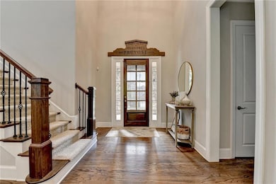 Entrance foyer with wood finished floors, stairway, and a towering ceiling