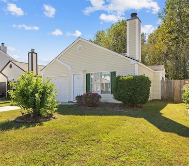 View of front of property with a chimney and a garage