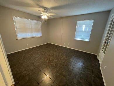 Empty room with ceiling fan and a textured ceiling