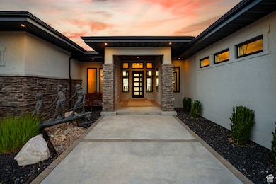 View of exterior entry with stucco siding and stone siding