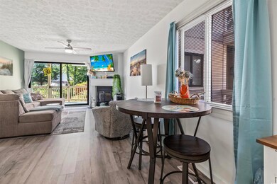 Living room with ceiling fan, a textured ceiling, 