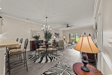 Dining space featuring wood finished floors, a ceiling fan, crown molding, a chandelier, and baseboards