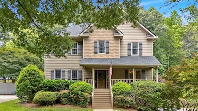 View of front of property with a shingled roof, a porch, and stairs