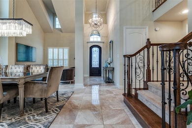 Entryway featuring a high ceiling, an inviting chandelier, and tile floors