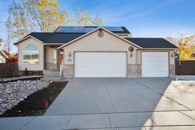 Ranch-style home featuring brick siding, driveway, an attached garage, and roof mounted solar panels