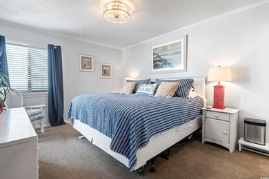 Bedroom with carpet floors, a textured ceiling, and ornamental molding