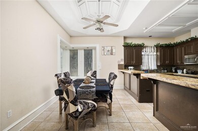 Tiled dining room with a tray ceiling and ceiling fan