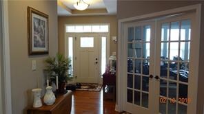 Foyer with tray ceiling, and private office