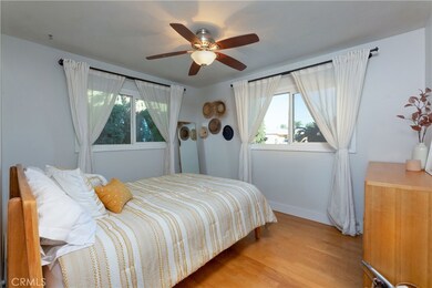 Second bedroom with ceiling fan and large windows.