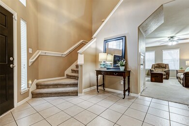 The entry features soaring ceilings and tile floor