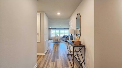Hallway featuring a textured wall, a textured ceiling, dark wood finished floors, and recessed lighting