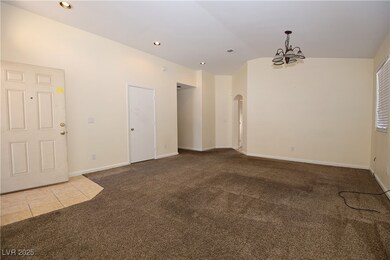 Carpeted empty room featuring arched walkways, a c
