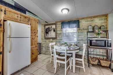Dining room with a textured ceiling, wood walls, a