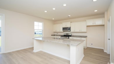 Kitchen with white cabinets, a center island with 