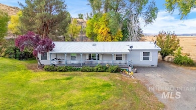 Single story home featuring covered porch, a front yard, a metal roof, and driveway