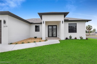 Doorway to property featuring a lawn and french do