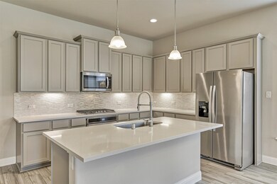 Gorgeous designer kitchen with stainless steel appliances and quartz counters.