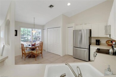 Kitchen with vaulted ceiling, white cabinets, appl