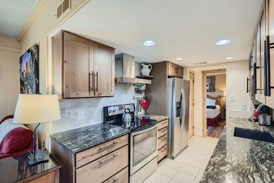 Kitchen featuring backsplash, wall chimney range h